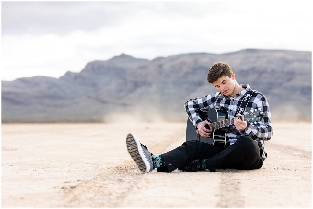 Senior Boy playing guitar dry lake bed nv